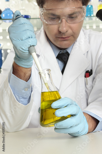 Scientist, resercher with pipette and erlenmeyer flask in lab. photo