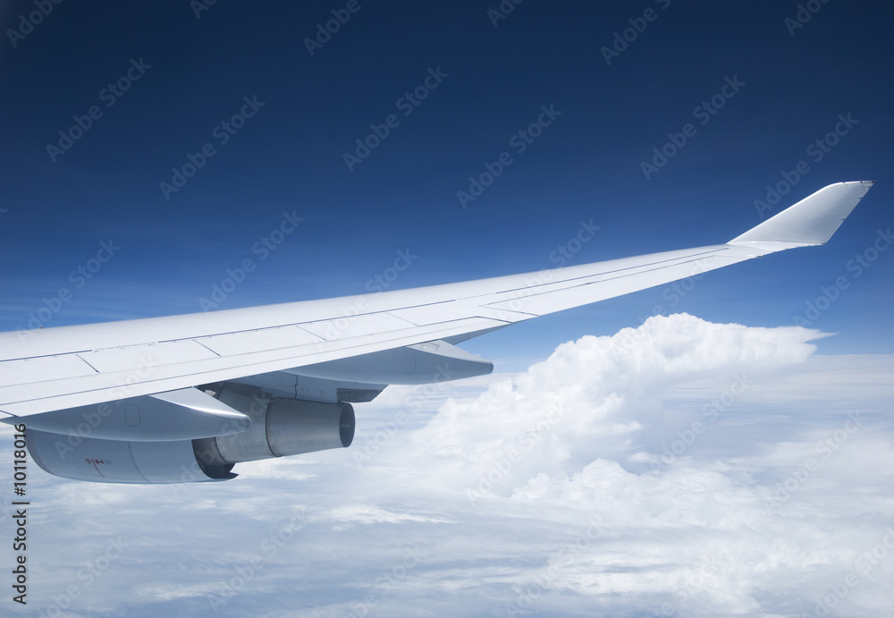 Obraz premium Wing and jet engine of passenger airplane flying