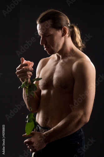 standing romantic man with pink rose.