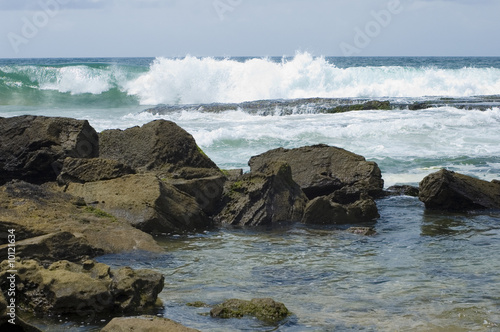 Waves and Rocks in a summer day .