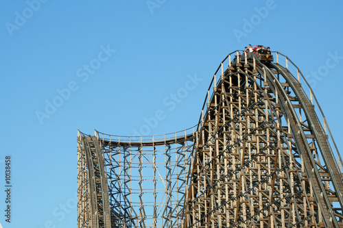 Wooden roller coaster support beams against blue sky