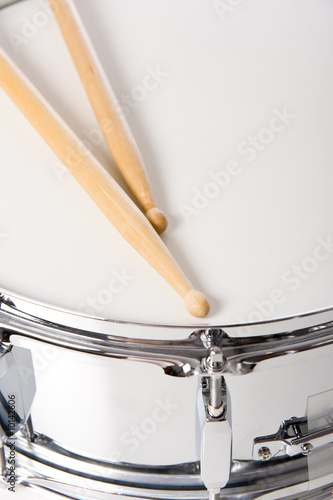 Photo A new silver snare drum with sticks on a white background