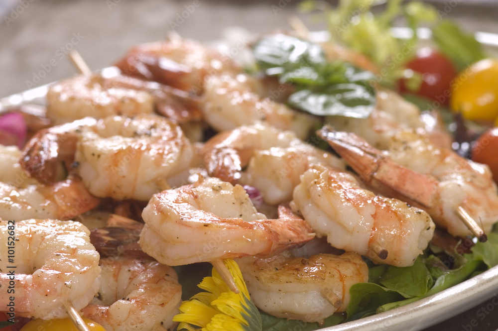 sauteed Shrimp on skewers over a bed of salad sauteed Shrimp on skewers over a bed of salad