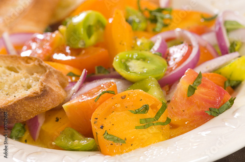 plate of tomato salad with red, green and yellow tomato's,