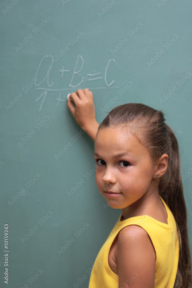 School girl writing on chalk board School girl writing on chalk board