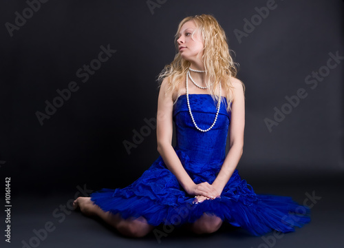 Beautiful girl in a dark blue dress and a pearl necklace