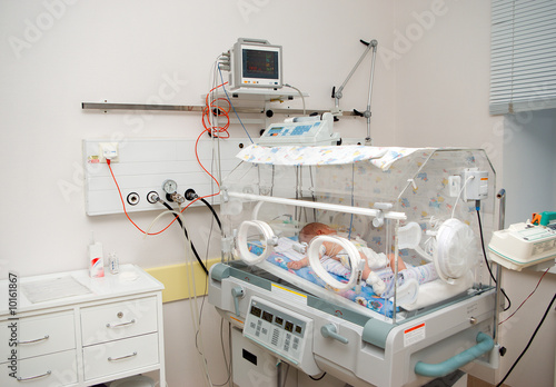 newborn baby sleeping in an incubator in hospital. photo