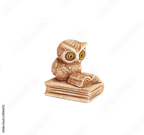 Figurine of a little owl sitting on a book and reading