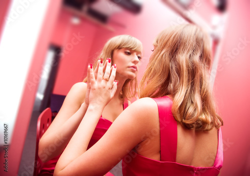 фотографія Woman beauty. Young woman in front of mirror in make-up room.