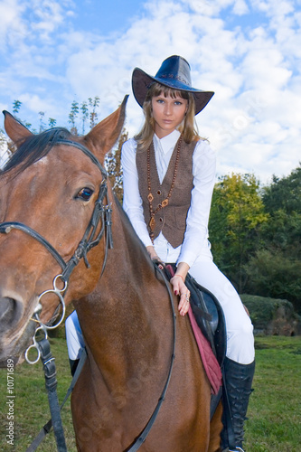 Pretty young woman riding beautiful horse.