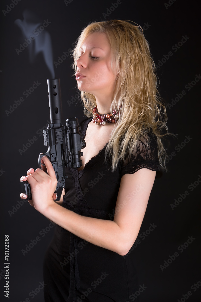 Girl blows a smoke from a trunk of a pistol Girl blows a smoke from a trunk of a pistol