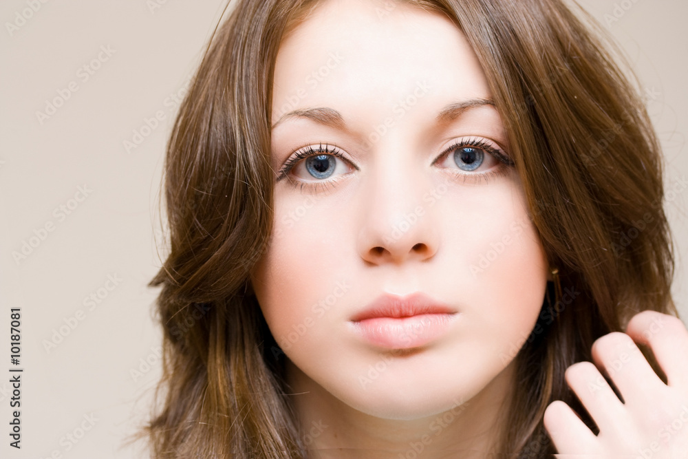 Beautiful girl with blue eyes arranging her hair, isolated Beautiful girl with blue eyes arranging her hair, isolated