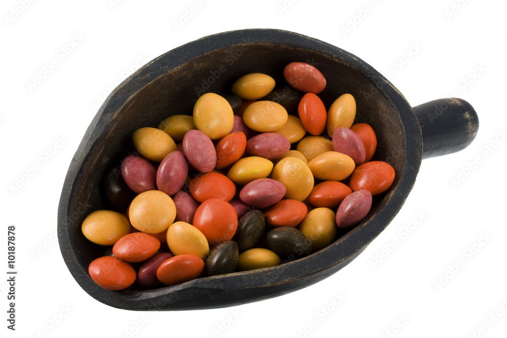 colorful coated chocolate candies on a wooden scoop colorful coated chocolate candies on a wooden scoop