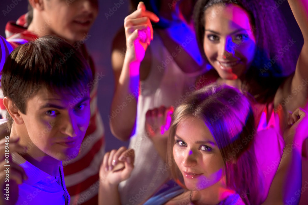 Smart teenagers looking at camera while dancing at disco Smart teenagers looking at camera while dancing at disco