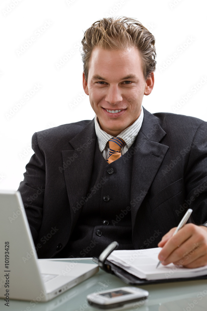 Businessman working on laptop computer, smiling, Businessman working on laptop computer, smiling,