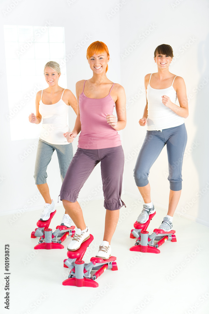 Fototapeta premium Women exercising on stepping machine