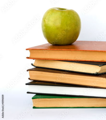Pile of books and apple isolated on white background