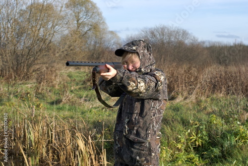 The girl in a camouflage aiming from a gun