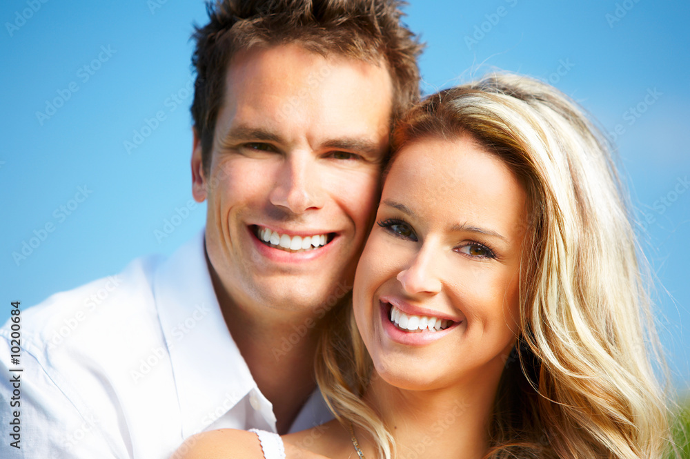 Young love couple smiling under blue sky. Young love couple smiling under blue sky.