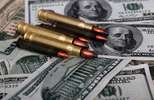 bullets lying on dollar banknotes