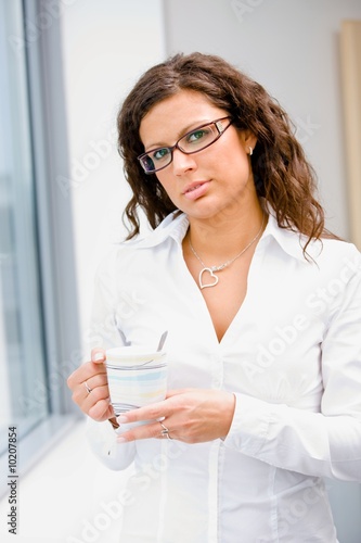 Young businesswoman standing in front of office window,