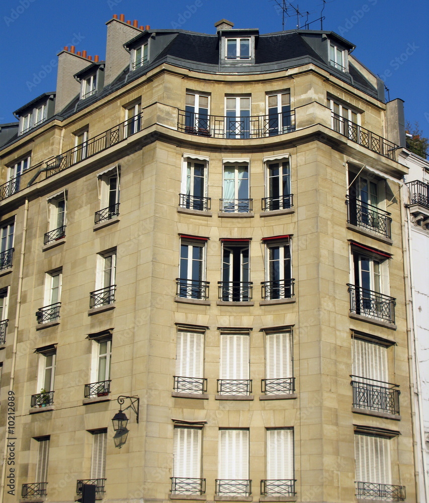 Obraz premium Immeuble concave en pierre, ciel bleu, Paris, France.