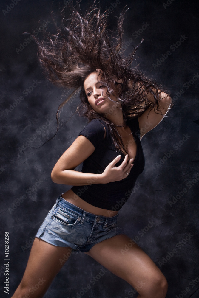 attractive young woman dancing, studio dark