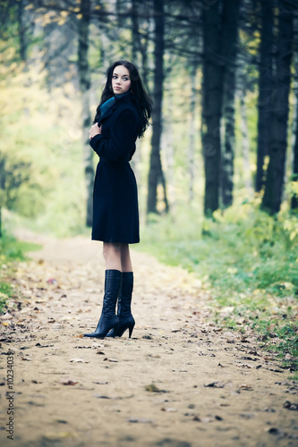 Slim brunette woman walking in a park. Autumn season.