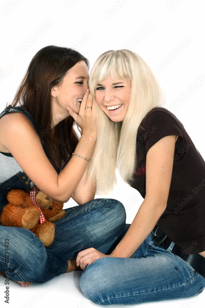 brunette and the blonde play with a toy bear brunette and the blonde play with a toy bear