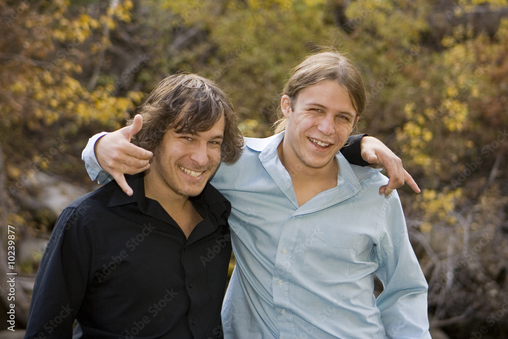 Brothers clowning around in a fall outdoor setting.
