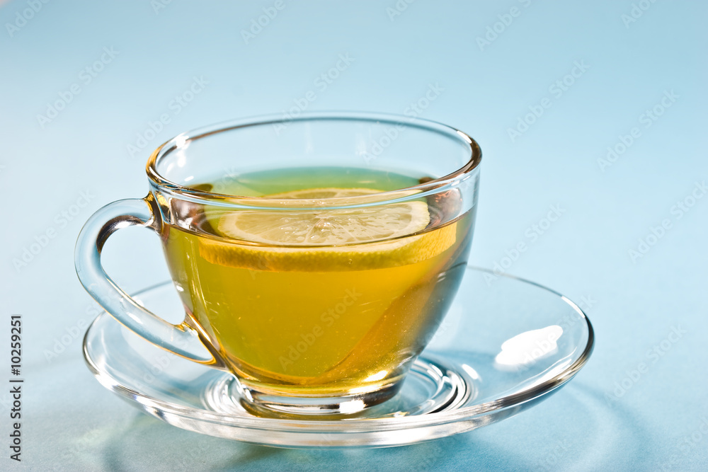 cup of tea with lemon over blue cup of tea with lemon over blue