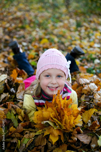 An image of girl in leaves in autumn park