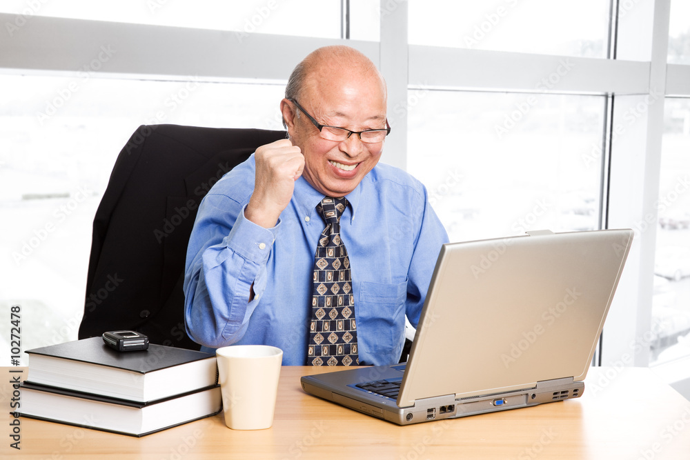 A senior asian businessman happy for success at the office A senior asian businessman happy for success at the office