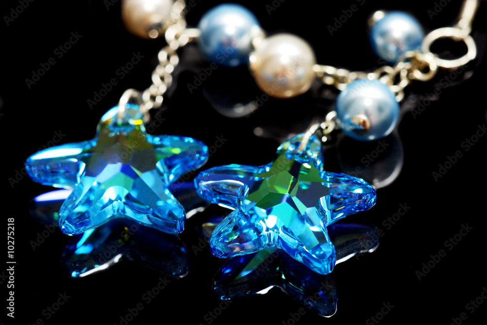 Close up of star shape bead earrings on black background. Close up of star shape bead earrings on black background.