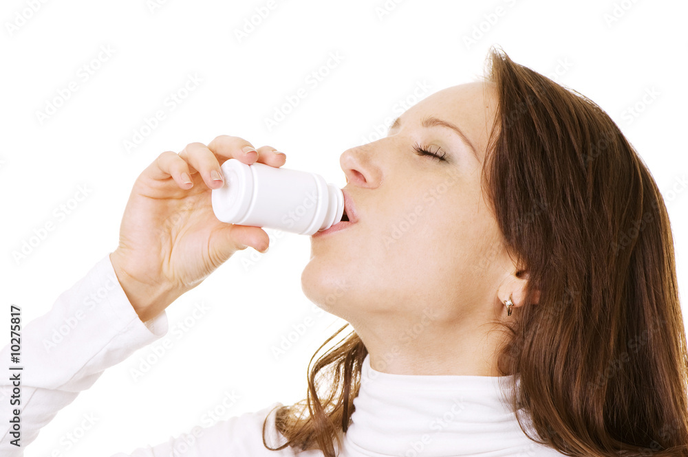pretty woman taking pills from bottle over white pretty woman taking pills from bottle over white