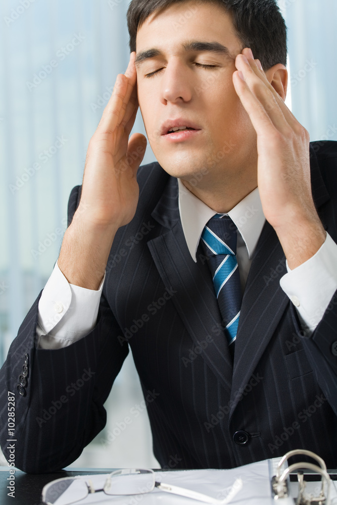 Photo of tired or unhealthy businessman at workplace Photo of tired or unhealthy businessman at workplace