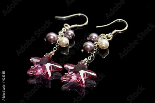 A pair of star shape bead earrings on black background.