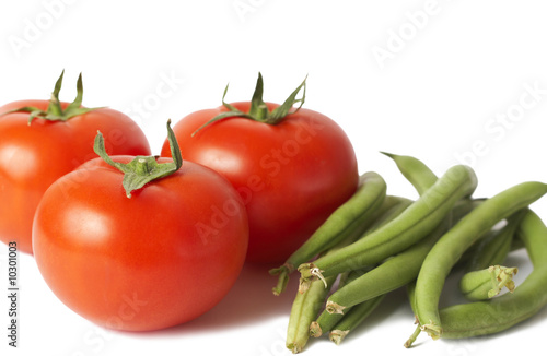 Three ripe red tomatoes and fresh green beans isolated