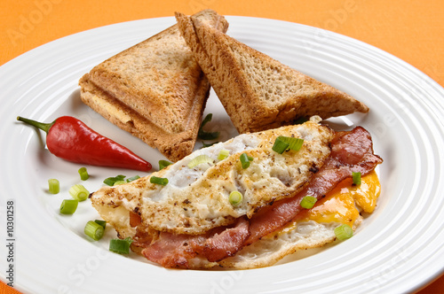 Breakfast - toasts, egg, bacon and vegetables
