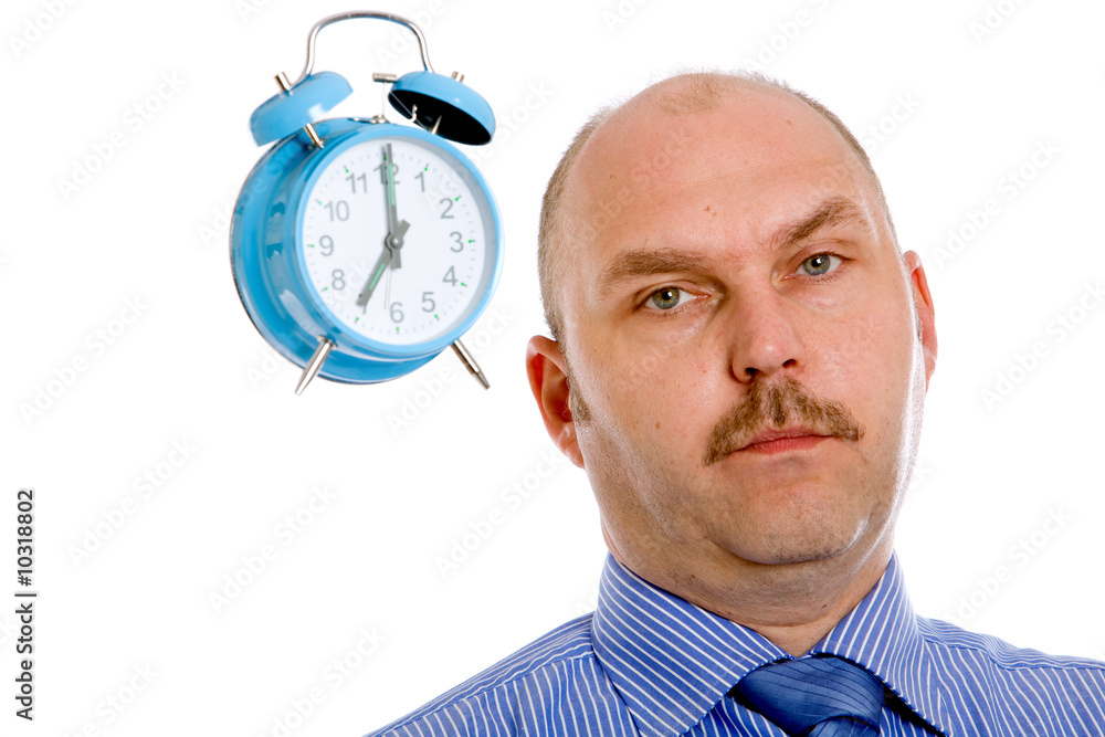 Businessman looking slightly annoyed with a clock Businessman looking slightly annoyed with a clock