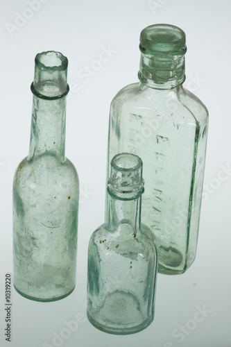 Three clear glass medicine bottles