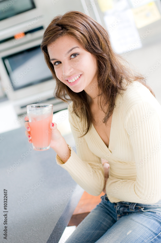 A beautiful young woman drinking grapefruit juice A beautiful young woman drinking grapefruit juice