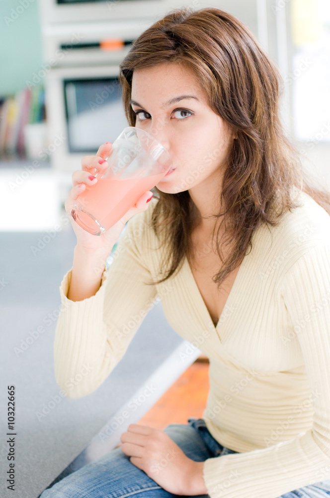 A beautiful young woman drinking grapefruit juice A beautiful young woman drinking grapefruit juice