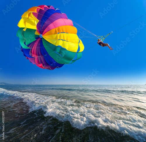 Man is parasailing in the blue sky photo
