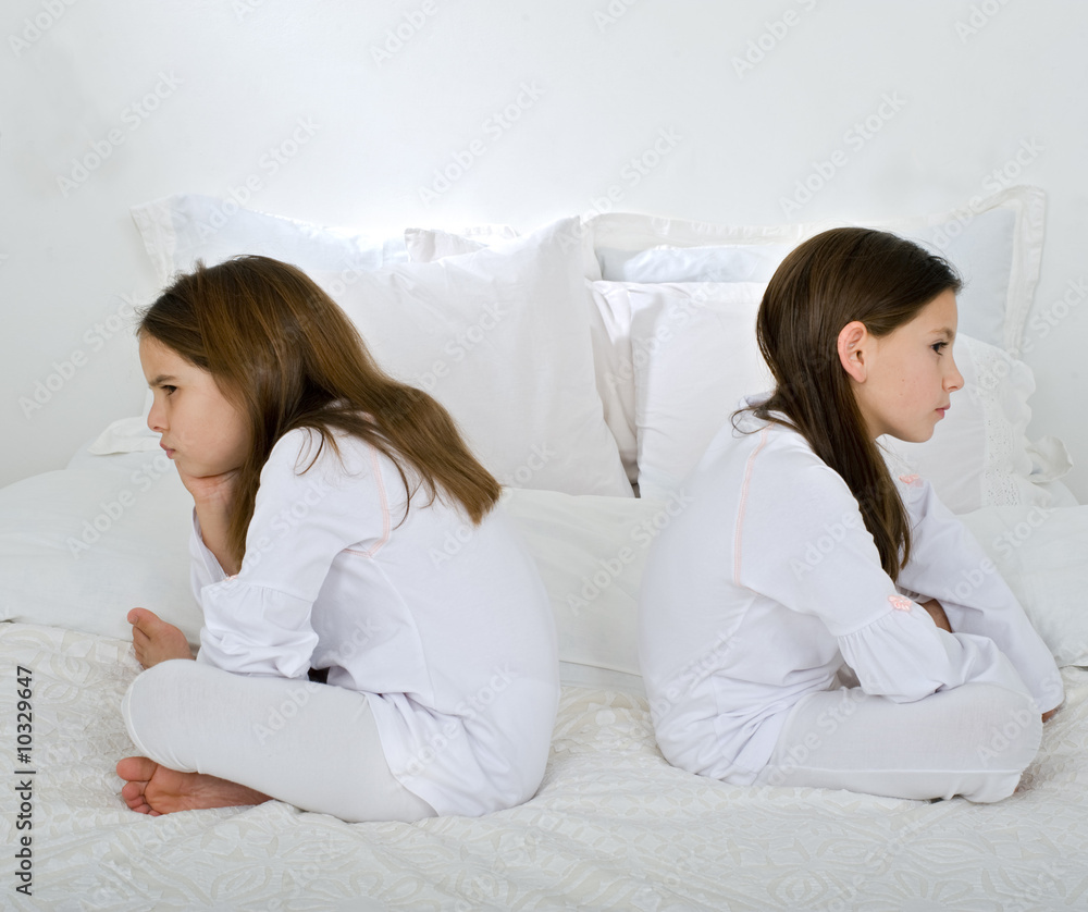 two little girls back to back in quarrel two little girls back to back in quarrel