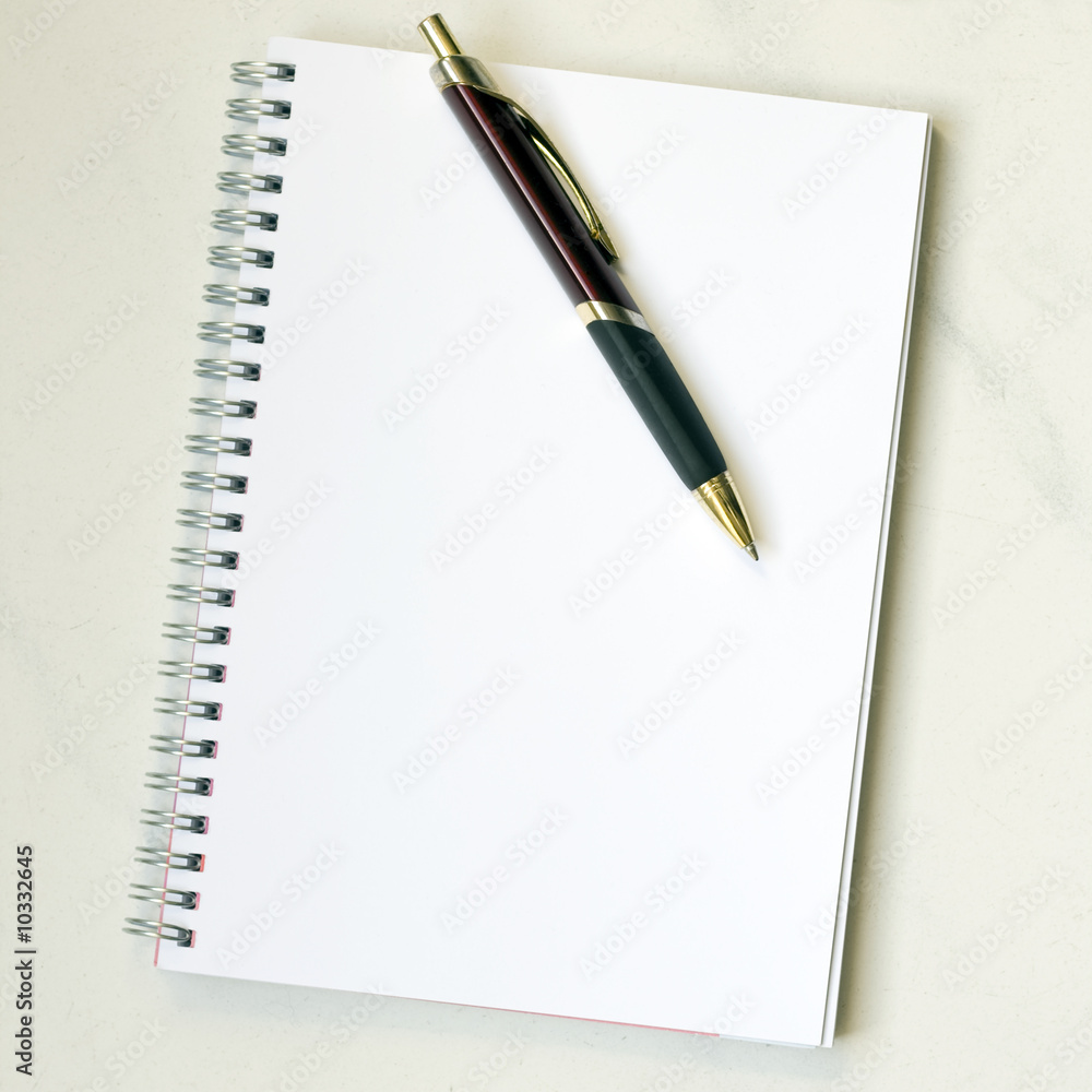 Spiral notepad with pen on marbled desk Spiral notepad with pen on marbled desk