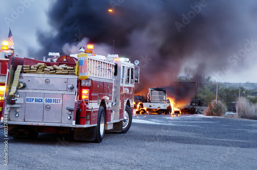 Firemen fight a fire that has involved  industrial trucks.