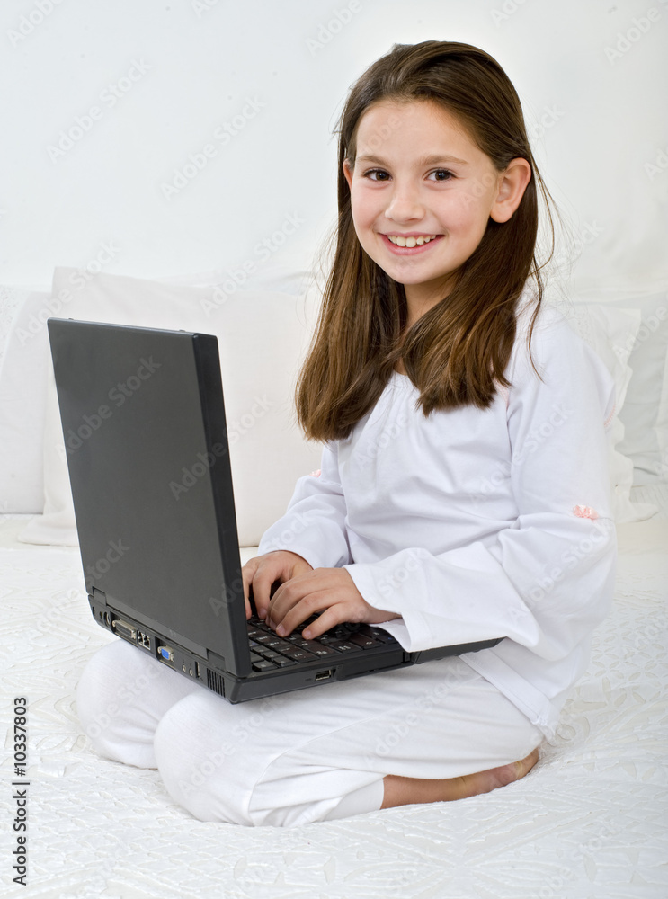 young girl with a laptop computer on the bed young girl with a laptop computer on the bed