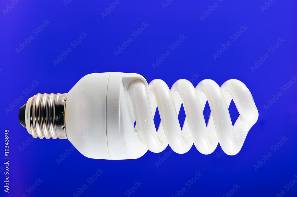 Twisted compact fluorescent lamp isolated on blue Twisted compact fluorescent lamp isolated on blue