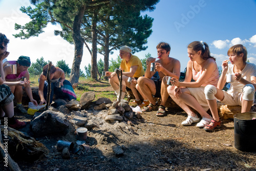 Hikers have breakfast in camp in mountains © Anton Gvozdikov